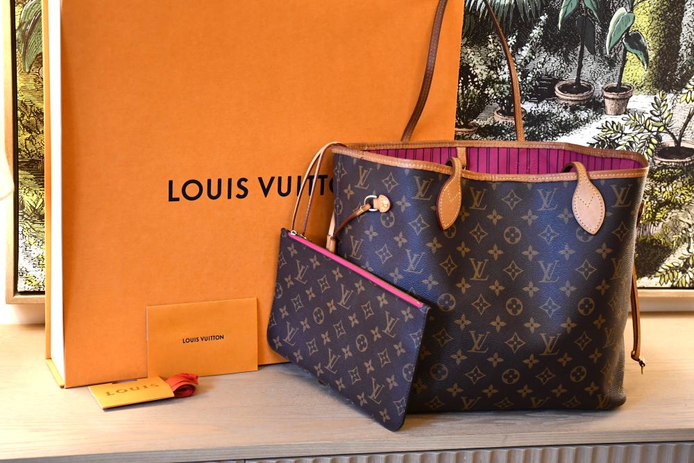 Pre owned Louis Vuitton MM Neverfull Mongram Bag  in front of orange LV box