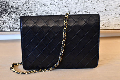 back of black quilted Chanel handbag with a gold leather entwined chain strap 